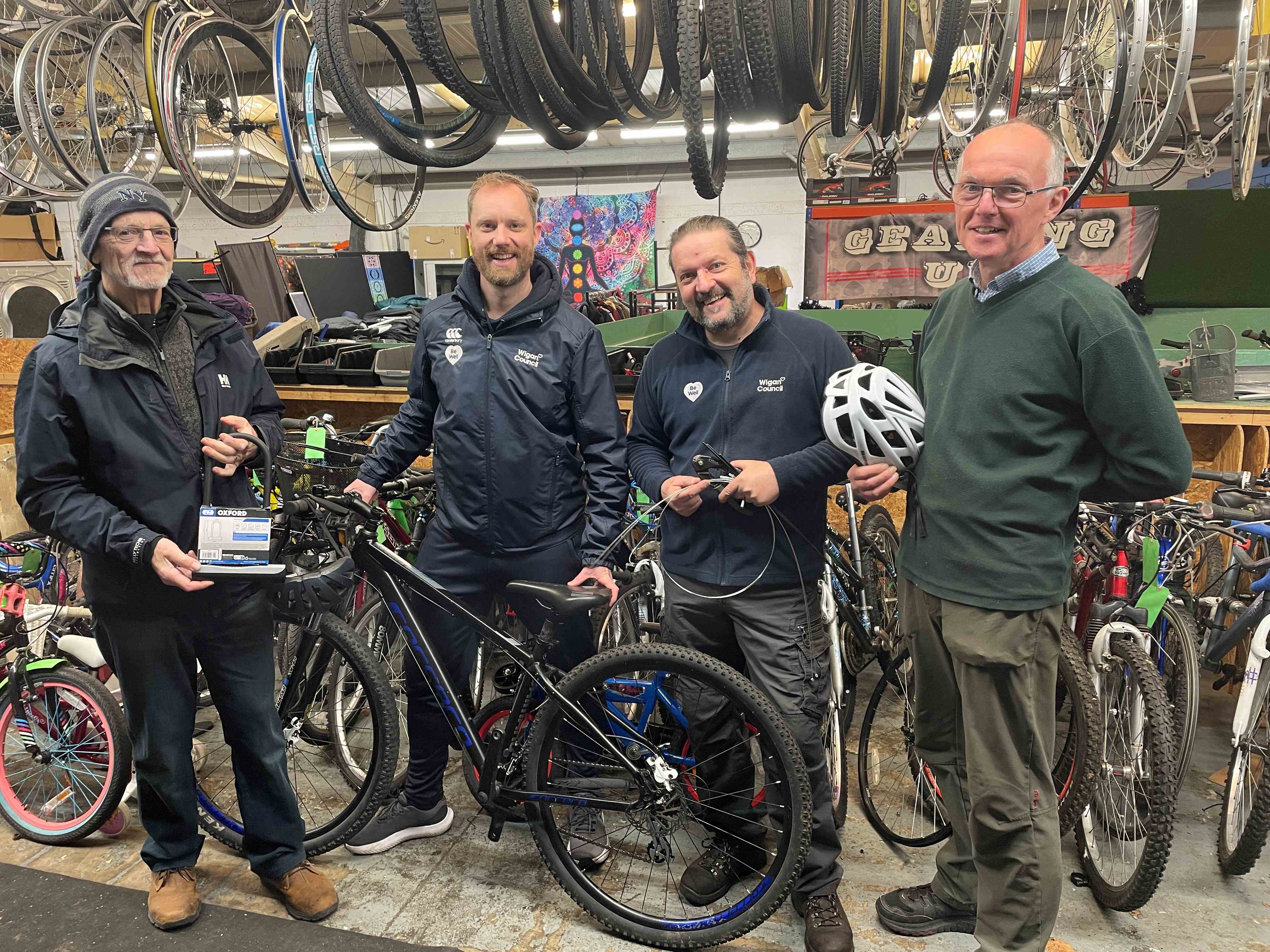 Four people standing behind a bike